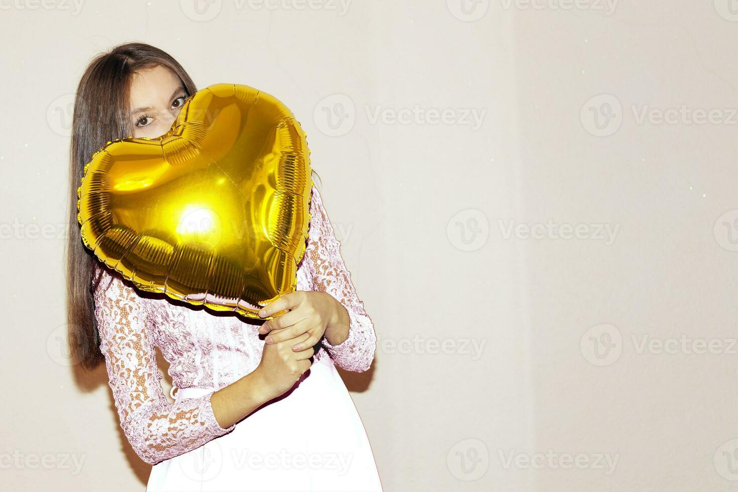 joven hermosa niña abrazando corazón conformado dorado aire globo. san valentin día, cumpleaños, De las mujeres día, aniversario, fiesta celebracion concepto foto