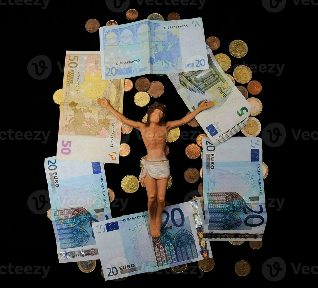 Jesús en el cruzar rodeado por dinero foto