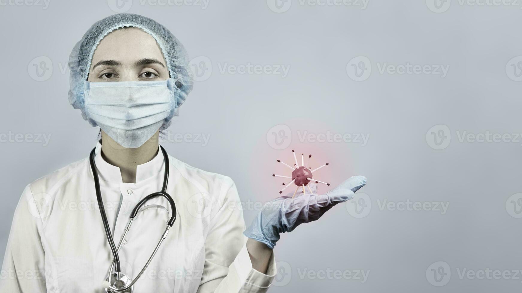 Female doctor in protective medical uniform holding coronavirus photo