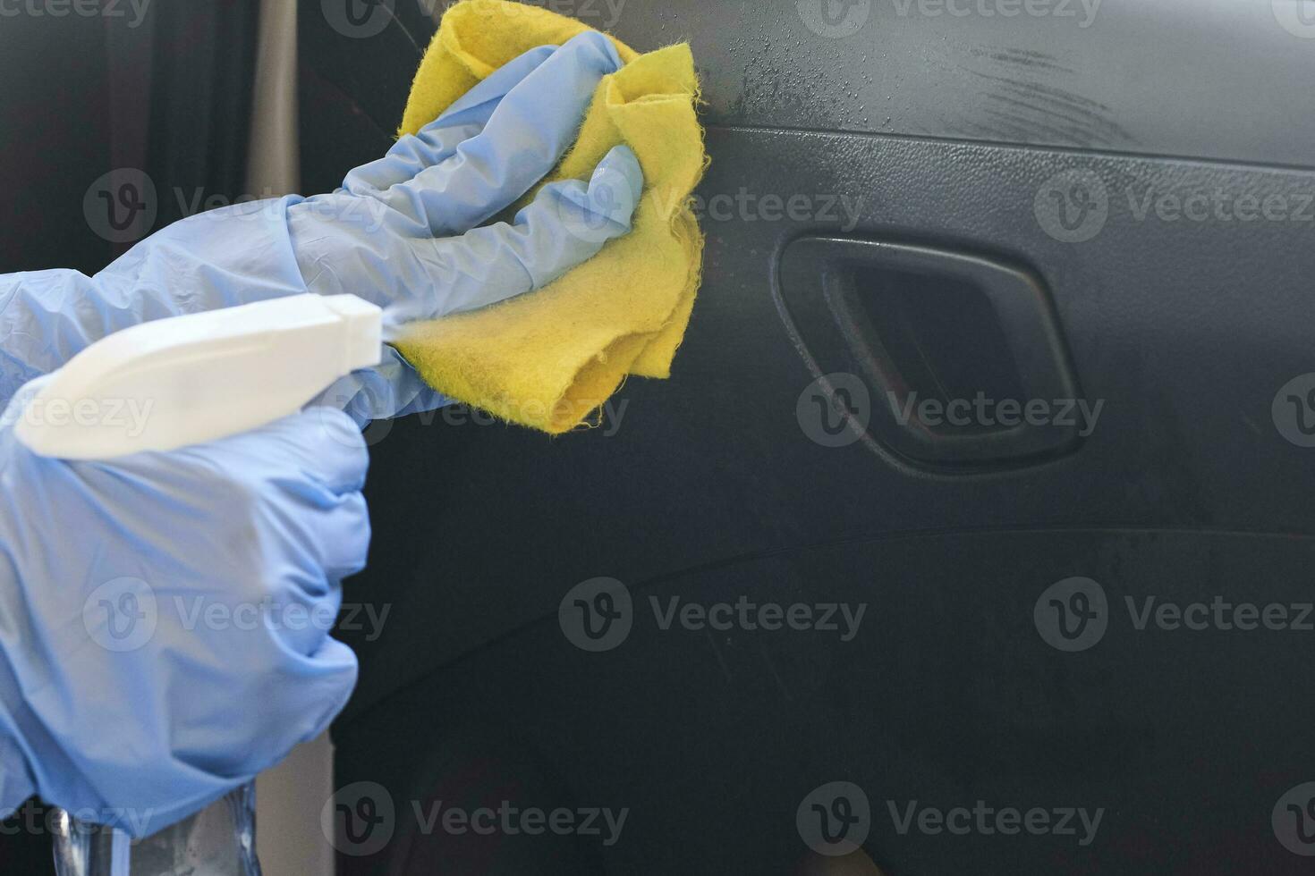 Car disinfecting service. Woman disinfecting inside car door handle photo