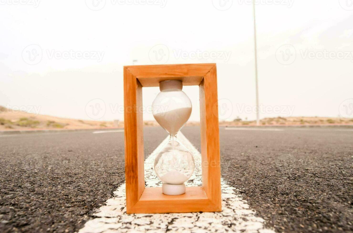 an hourglass is sitting in the middle of a road photo