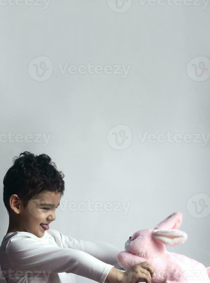 5 years adorable little kid boy playing with plush rabbit bunny toy photo