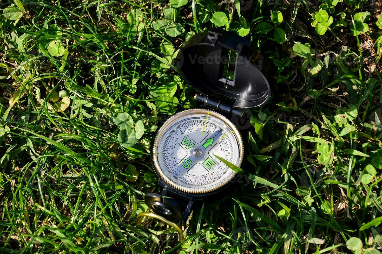 a compass is laying on the grass photo