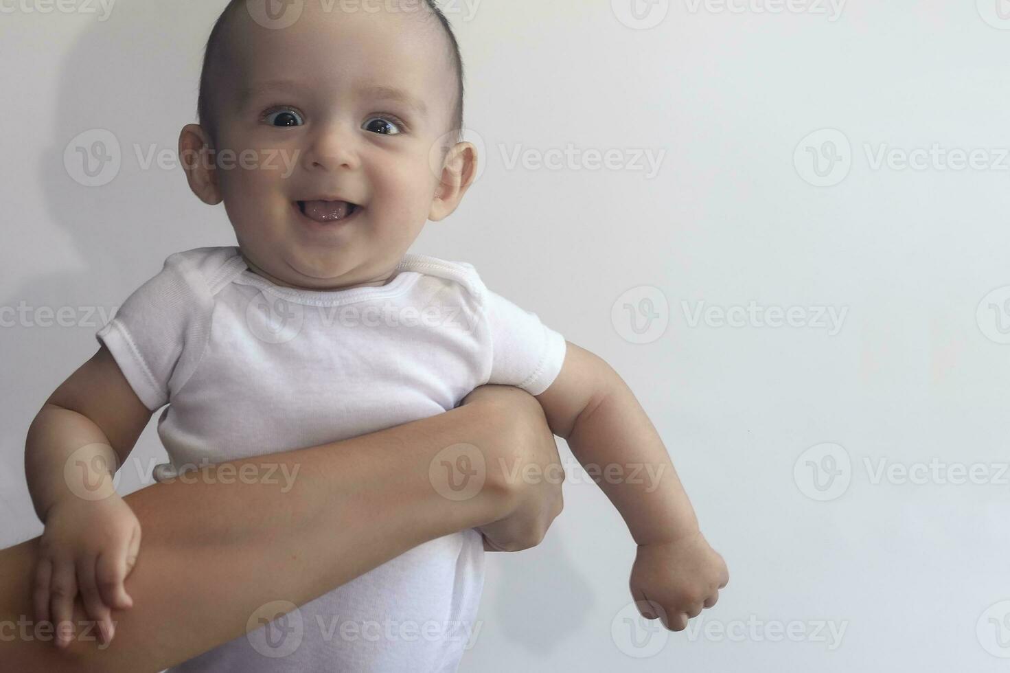 Mother and baby. Mom holding her 6 months baby boy. Beautiful baby boy of six months in his mother's hands. Young middle eastern mother holding in her arms her little son photo