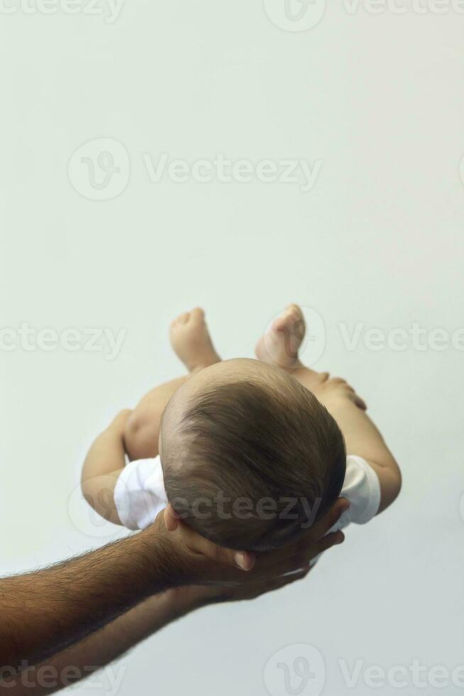 Dad holding 6-month-old baby boy against the white background. Father picking up his baby. Copy space. Family concept photo