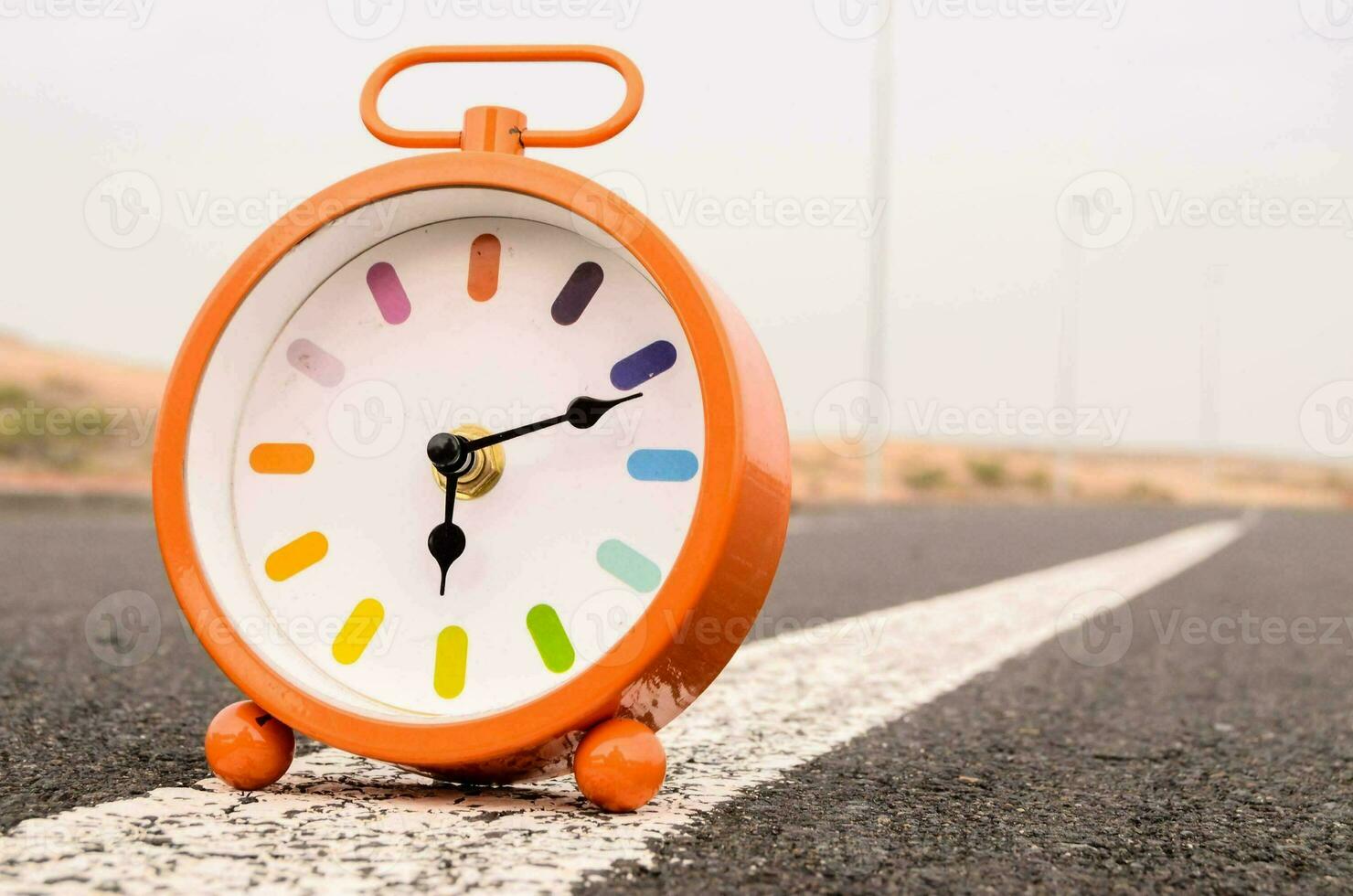 an orange alarm clock sitting in the road photo