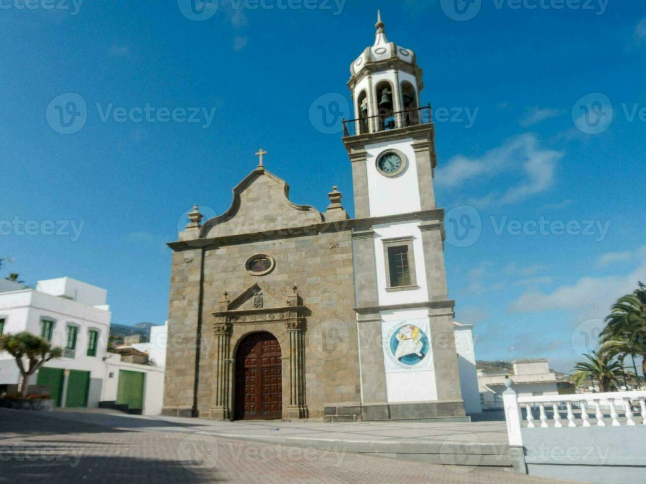 a church with a clock tower in the middle of a town photo