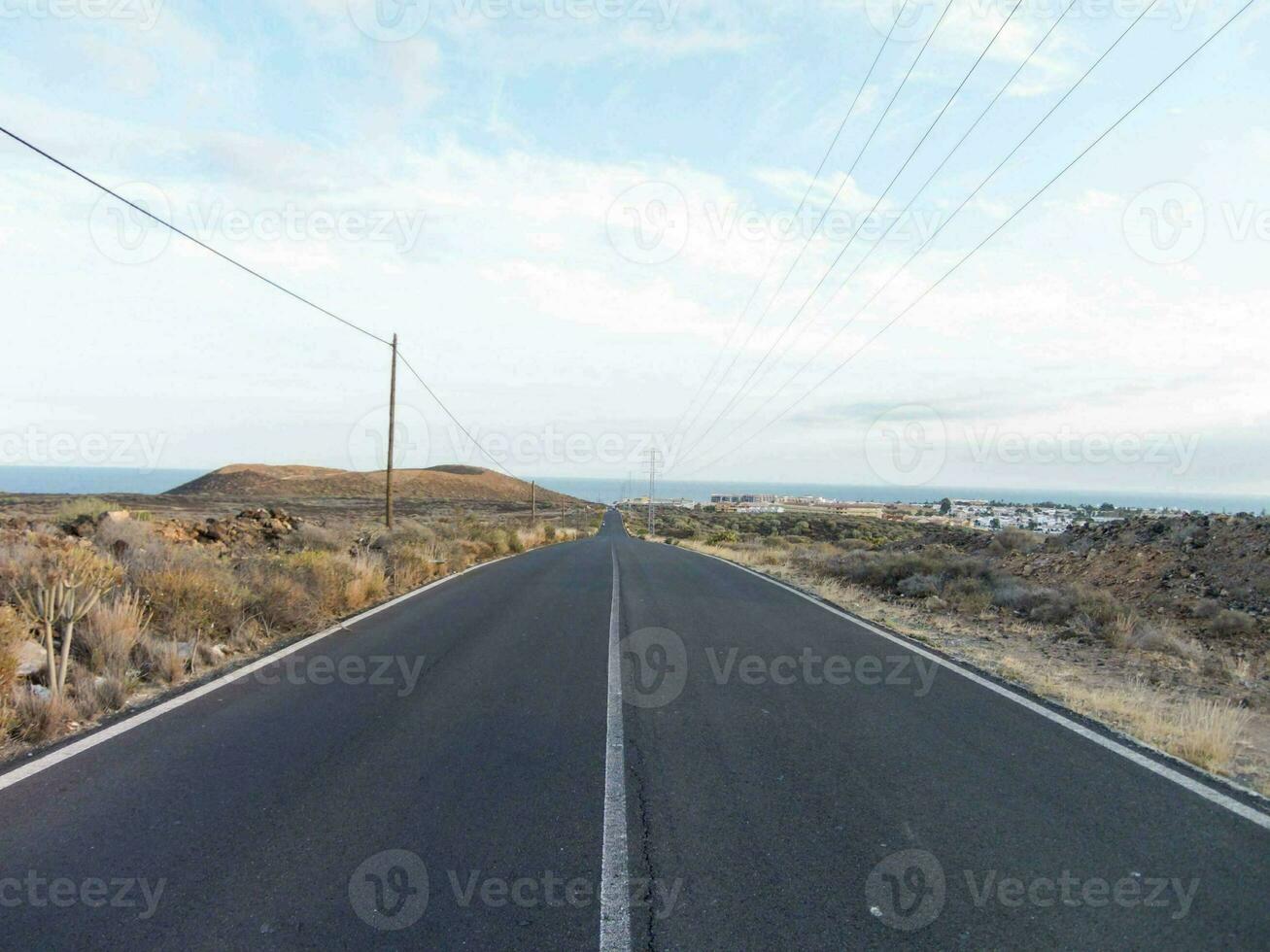 an empty road with a power line in the distance photo