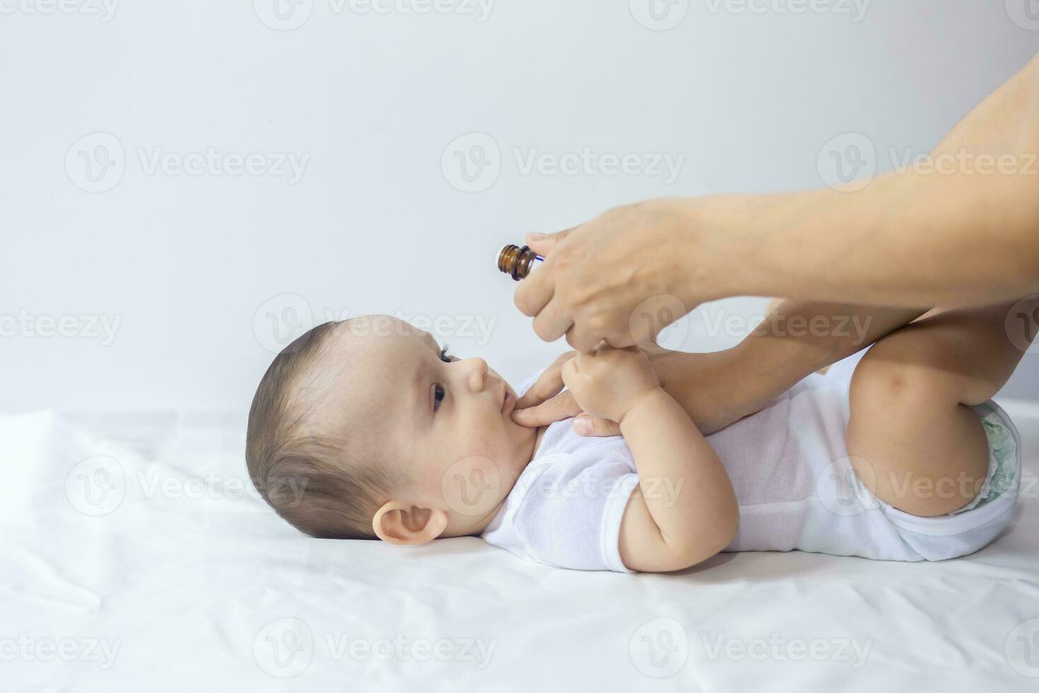 A doctor gives newborn baby rotavirus vaccine. Child immunization with little drop in clinic.Baby boy gets medicine from a little bottle photo