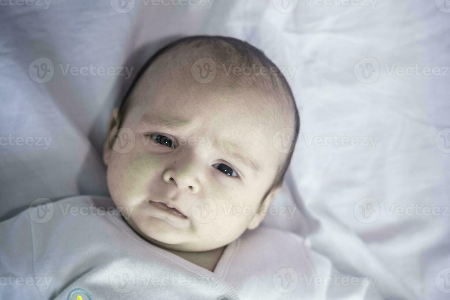 linda pequeño bebé chico. retrato de recién nacido infantil bebé chico acostado en el blanco foto