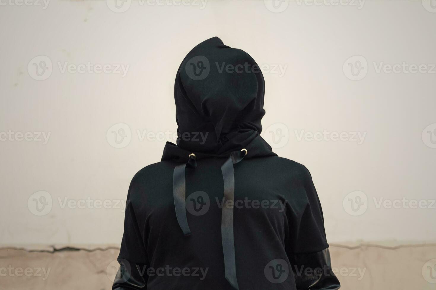 Woman head covered with black textile. Victim, slave, hostage. Woman with veiled face. The concept of kidnapping, detention, and crime. No face. Woman with cloth bag on head photo