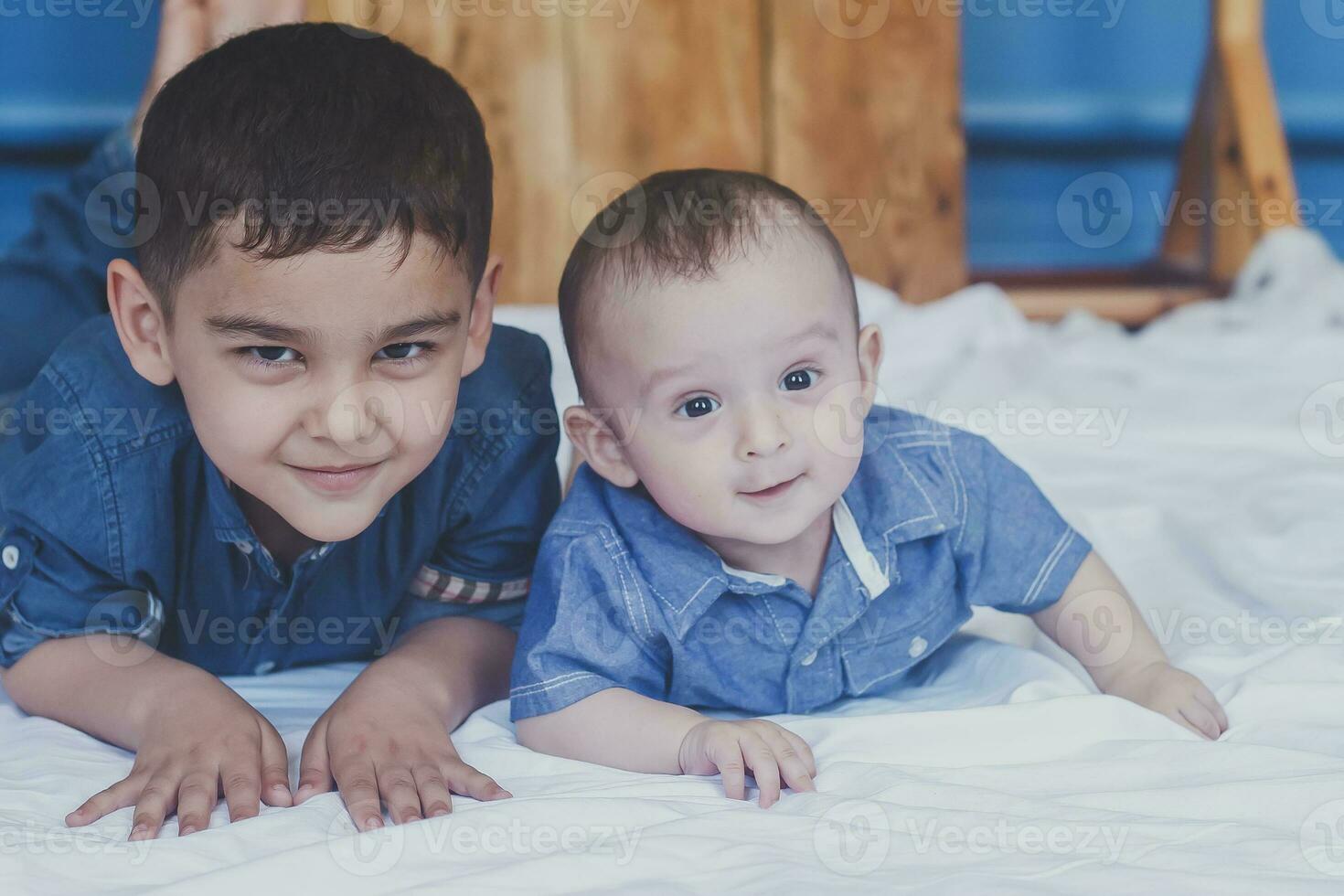 Happy childhood concept. Happy brothers portrait. 6 years and 6 months old boys having fun. Two little kids smiling having good time. Cute little brothers lying and playing together photo