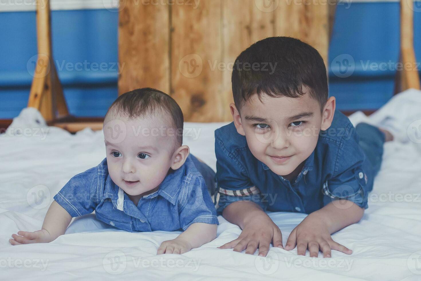 Happy childhood concept. Happy brothers portrait. 6 years and 6 months old boys having fun. Two little kids smiling having good time. Cute little brothers lying and playing together photo