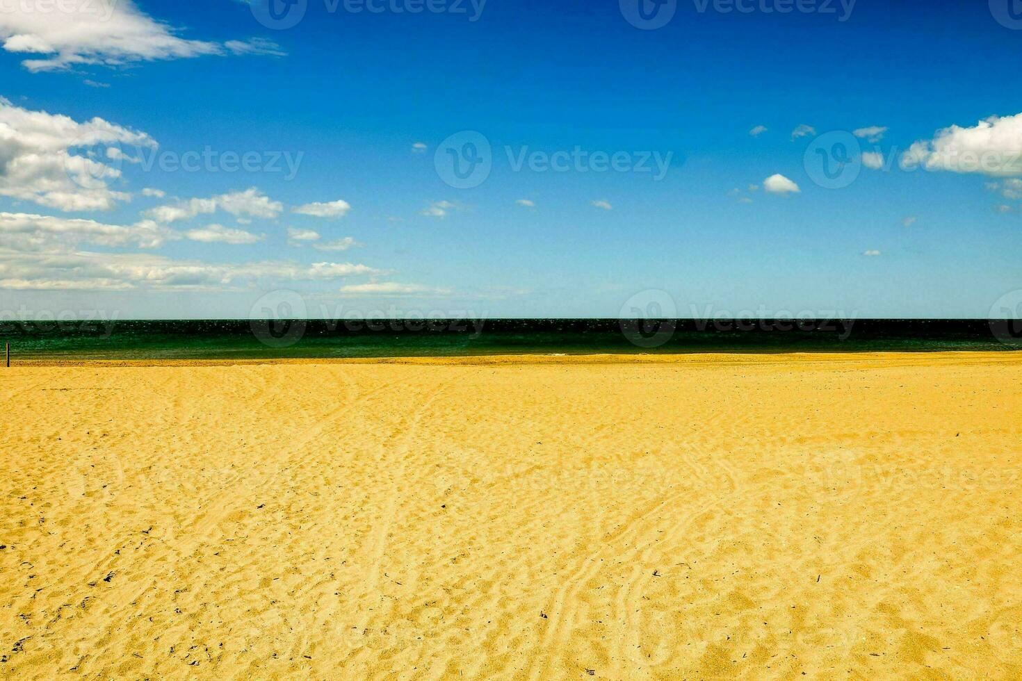 a sandy beach with blue sky and clouds photo