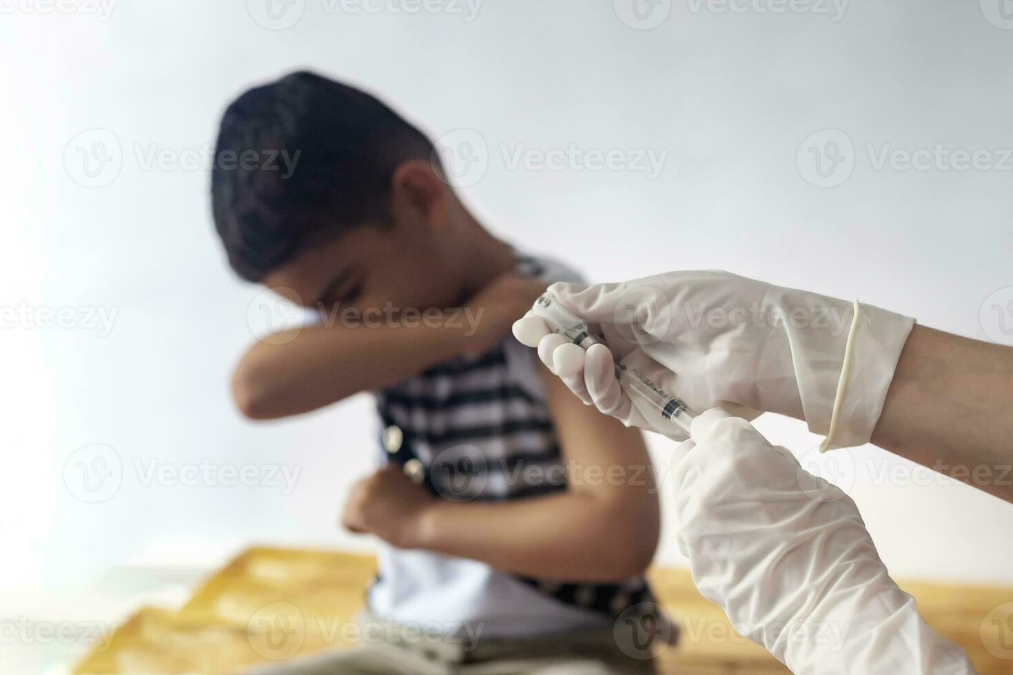 A doctor vaccinating young patient. Little boy scared of injection. Child's Immunization, Children's Vaccination, Health concept. photo