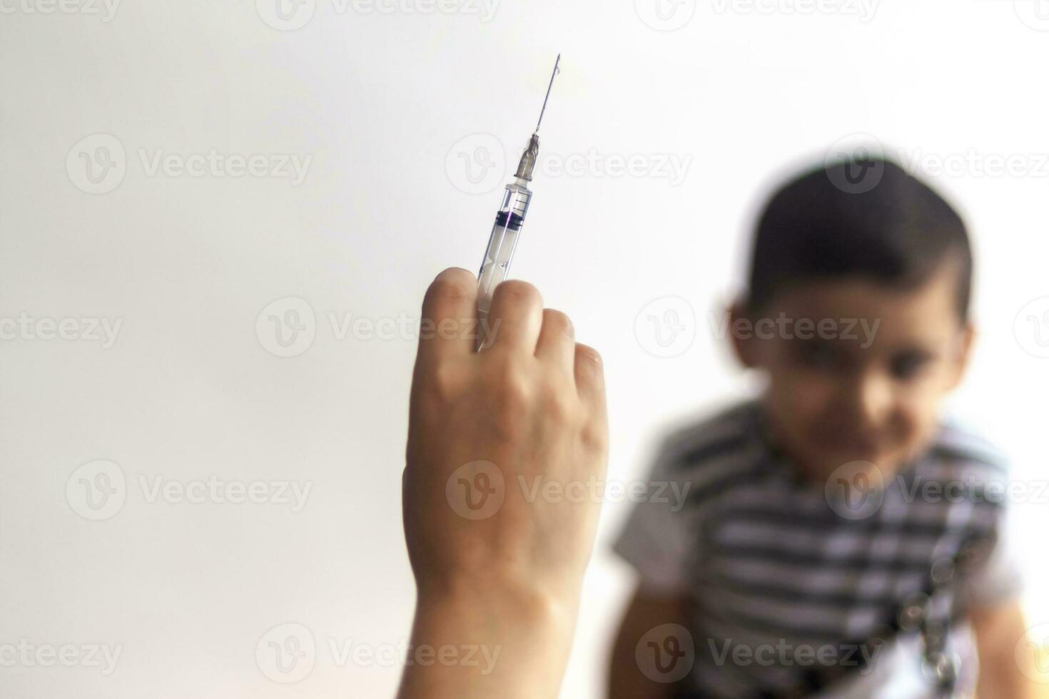A doctor vaccinating young patient. Little boy scared of injection. Child's Immunization, Children's Vaccination, Health concept. photo
