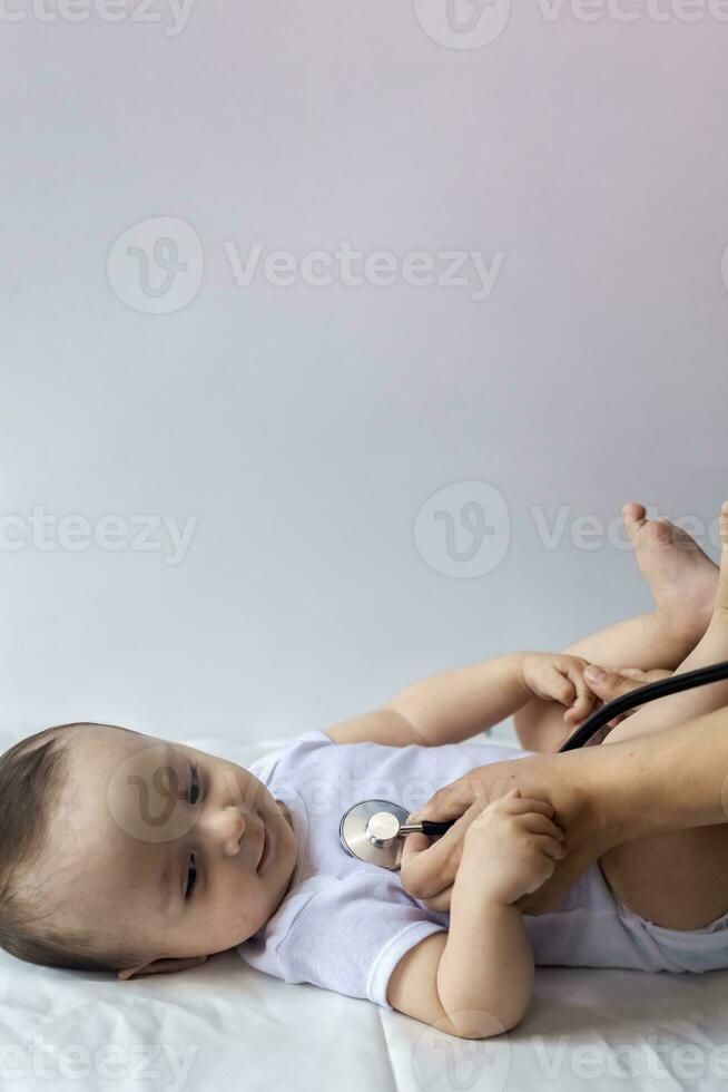 The Physical Checkup. Baby's Checkup. The pediatrician examining little boy with a stethoscope. Doctor examining the 6-month old baby boy. photo