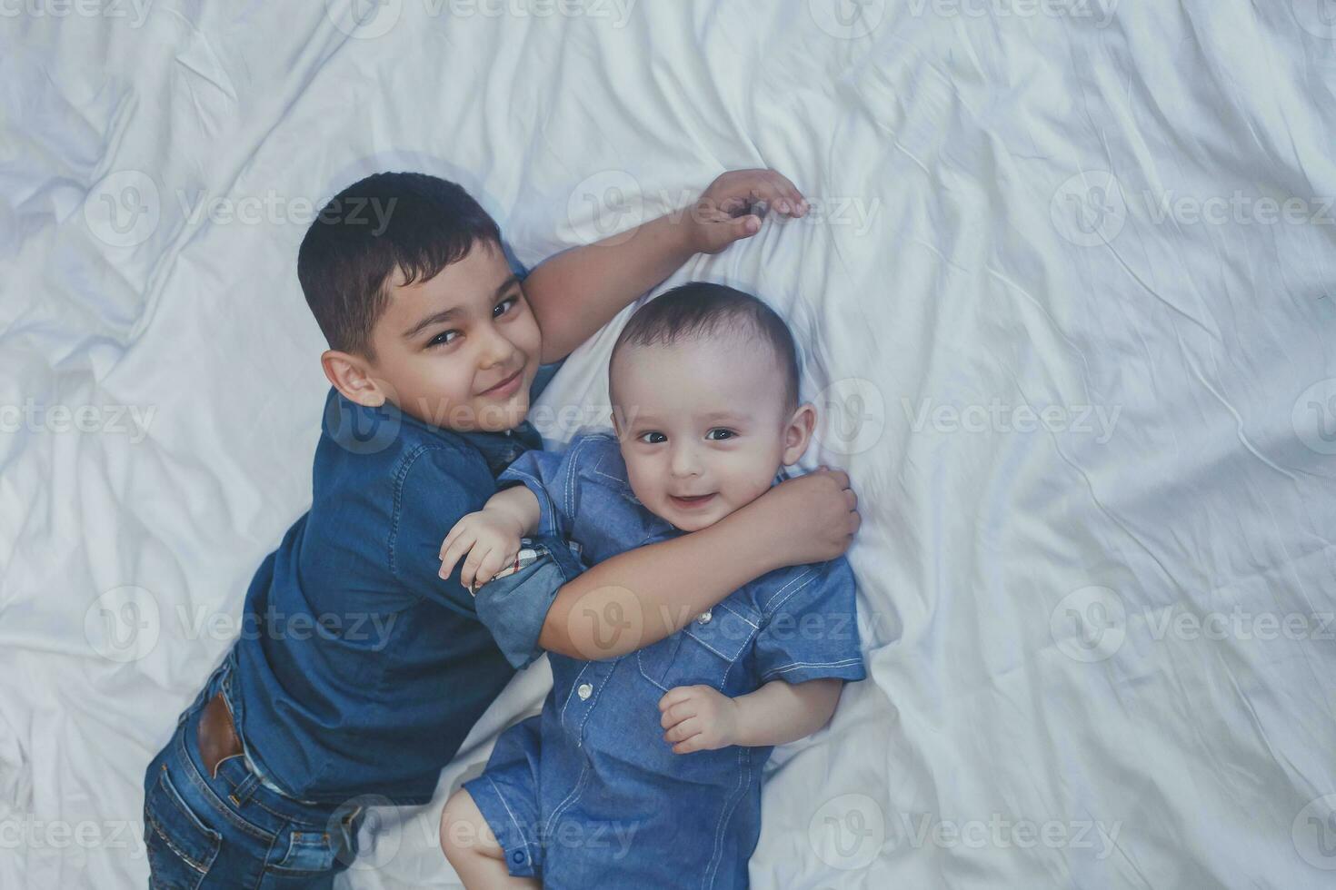 Happy childhood concept. Happy brothers portrait. 6 years and 6 months old boys having fun. Two little kids smiling having good time. Cute little brothers lying and playing together photo