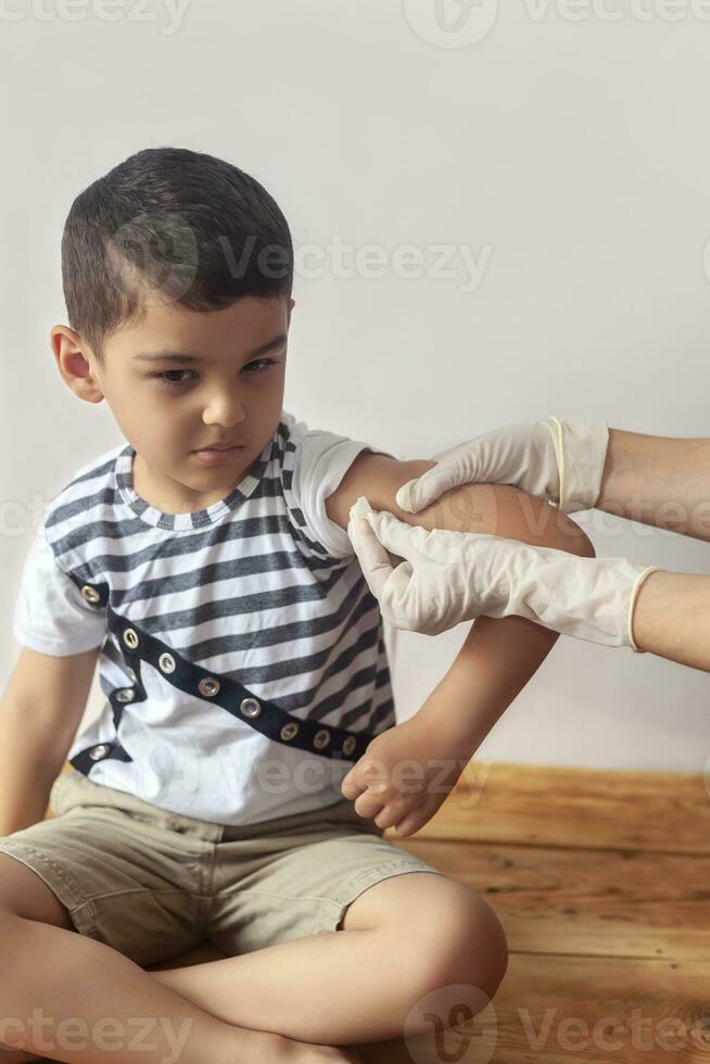 A doctor vaccinating young patient. Little boy scared of injection. Child's Immunization, Children's Vaccination, Health concept. photo