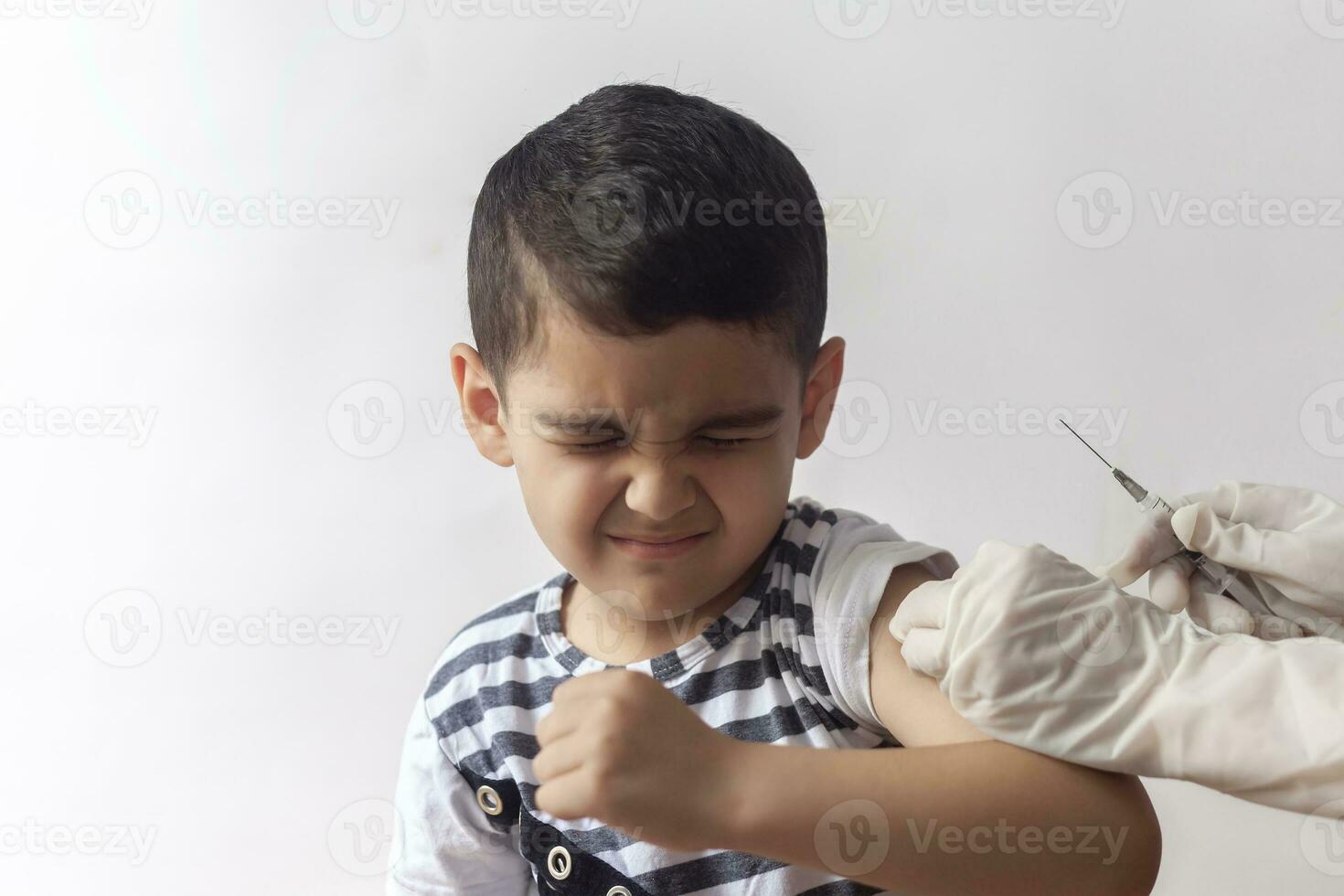 A doctor vaccinating young patient. Little boy scared of injection. Child's Immunization, Children's Vaccination, Health concept. photo