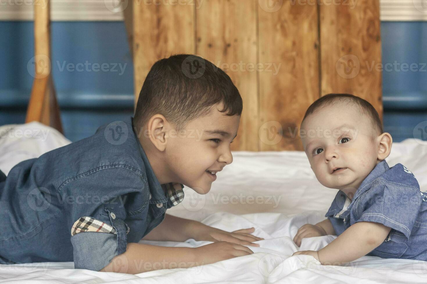 Happy childhood concept. Happy brothers portrait. 6 years and 6 months old boys having fun. Two little kids smiling having good time. Cute little brothers lying and playing together photo