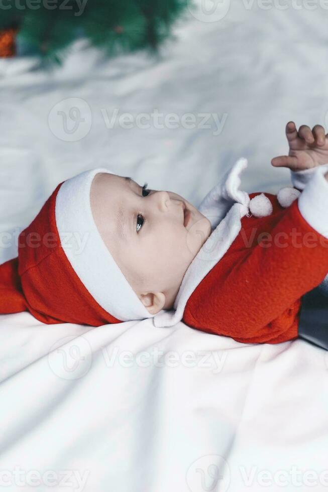 pequeño Papa Noel. 6-9 meses antiguo bebé chico en Papa Noel claus traje. alegre Navidad foto