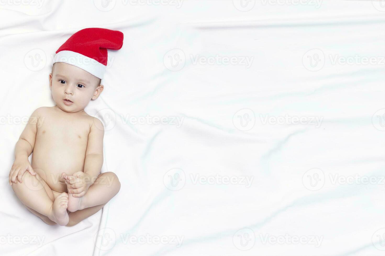 9 month baby boy with Santa Claus hat. Christmas morning. Little kid playing. photo