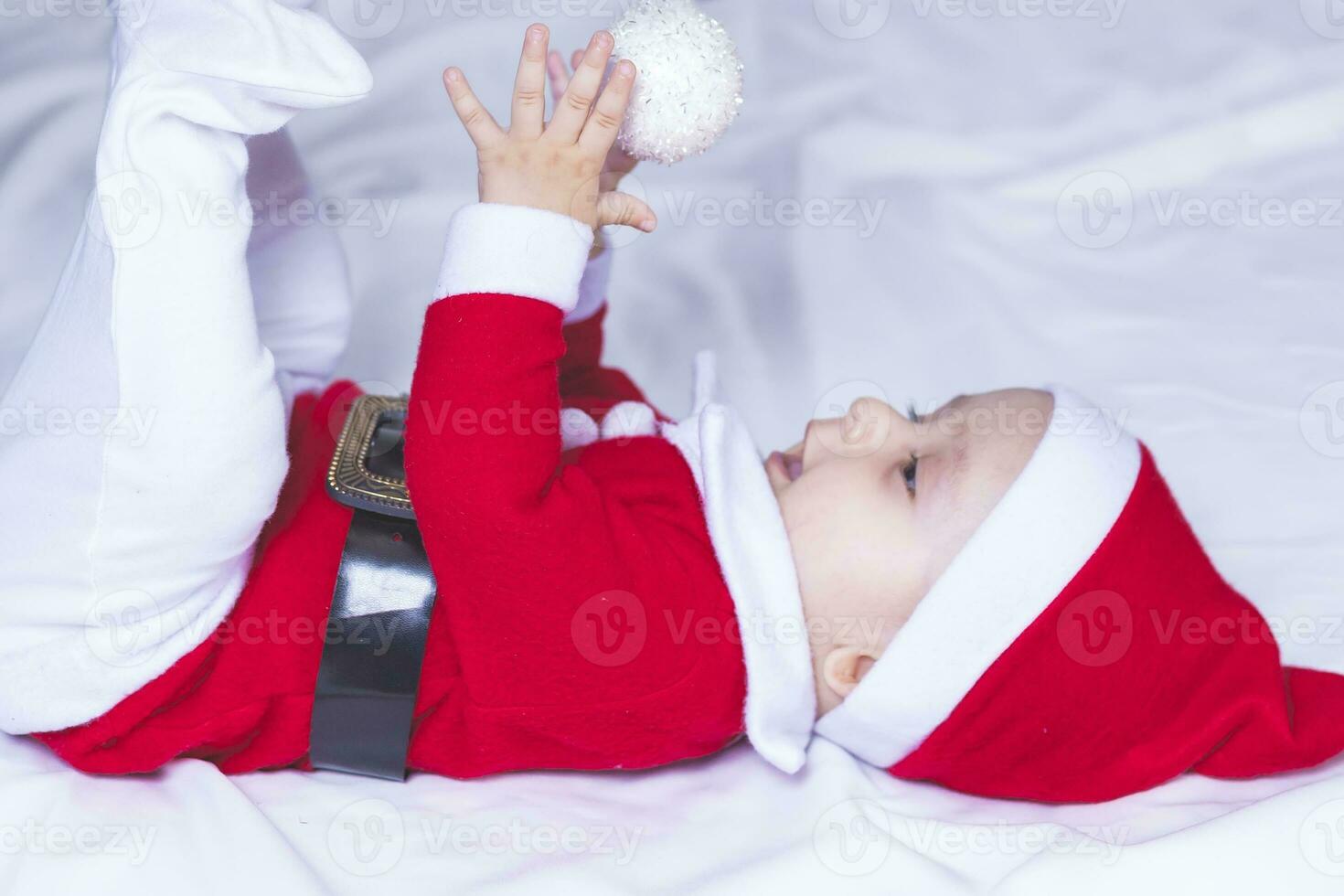 pequeño Papa Noel. 6-9 meses antiguo bebé chico en Papa Noel claus traje. alegre Navidad foto