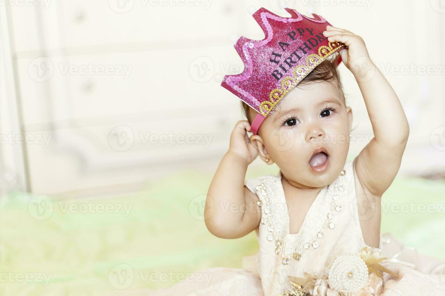 primero cumpleaños. pequeño alegre bebé niña con corona celebrando su primero cumpleaños fiesta foto