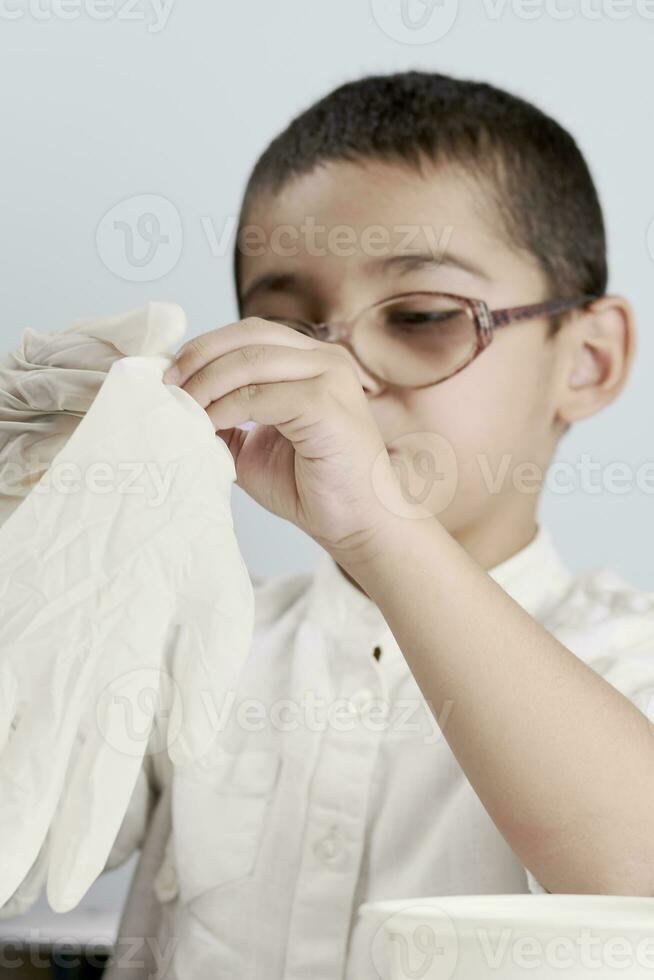 Little scientist wearing protective glove photo