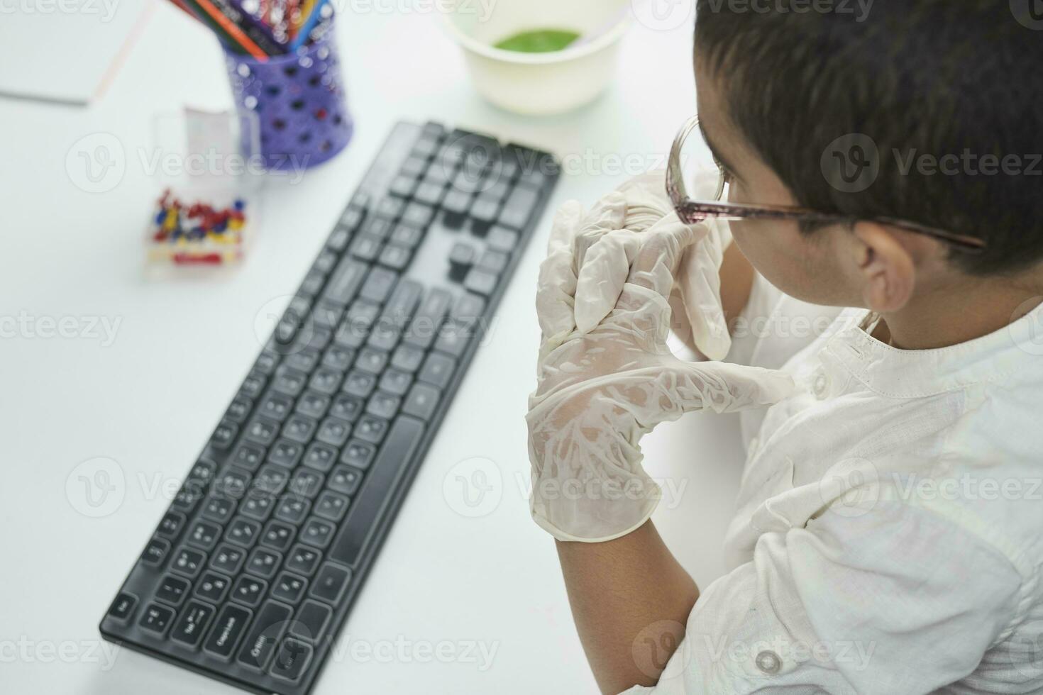 Overhead view of schoolboy typing on keyboard photo