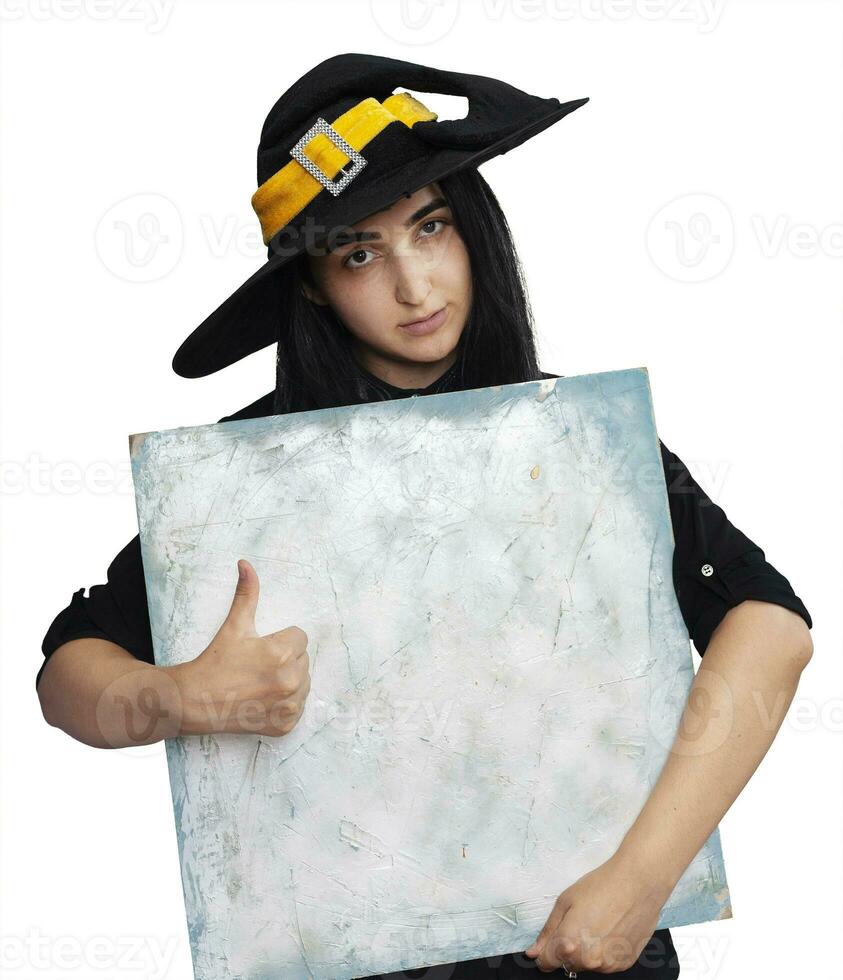 Halloween girl in witch costume holding blank board photo