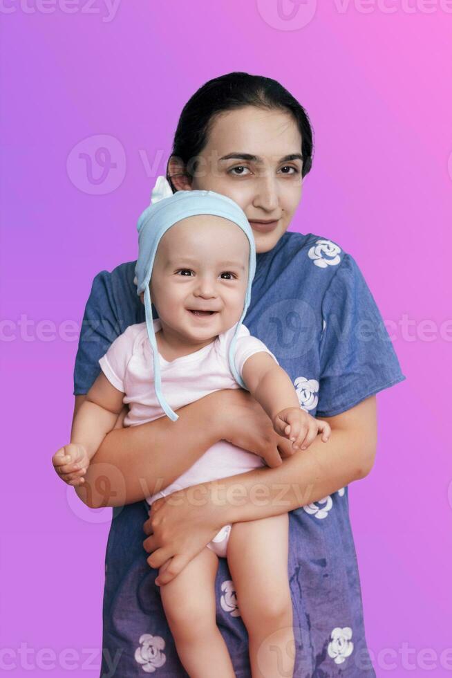 Portrait of happy mother and cute baby boy. Middle eastern woman holding her little baby photo