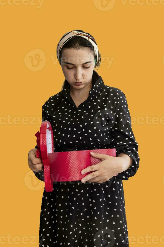 Unhappy woman opening a red gift box photo