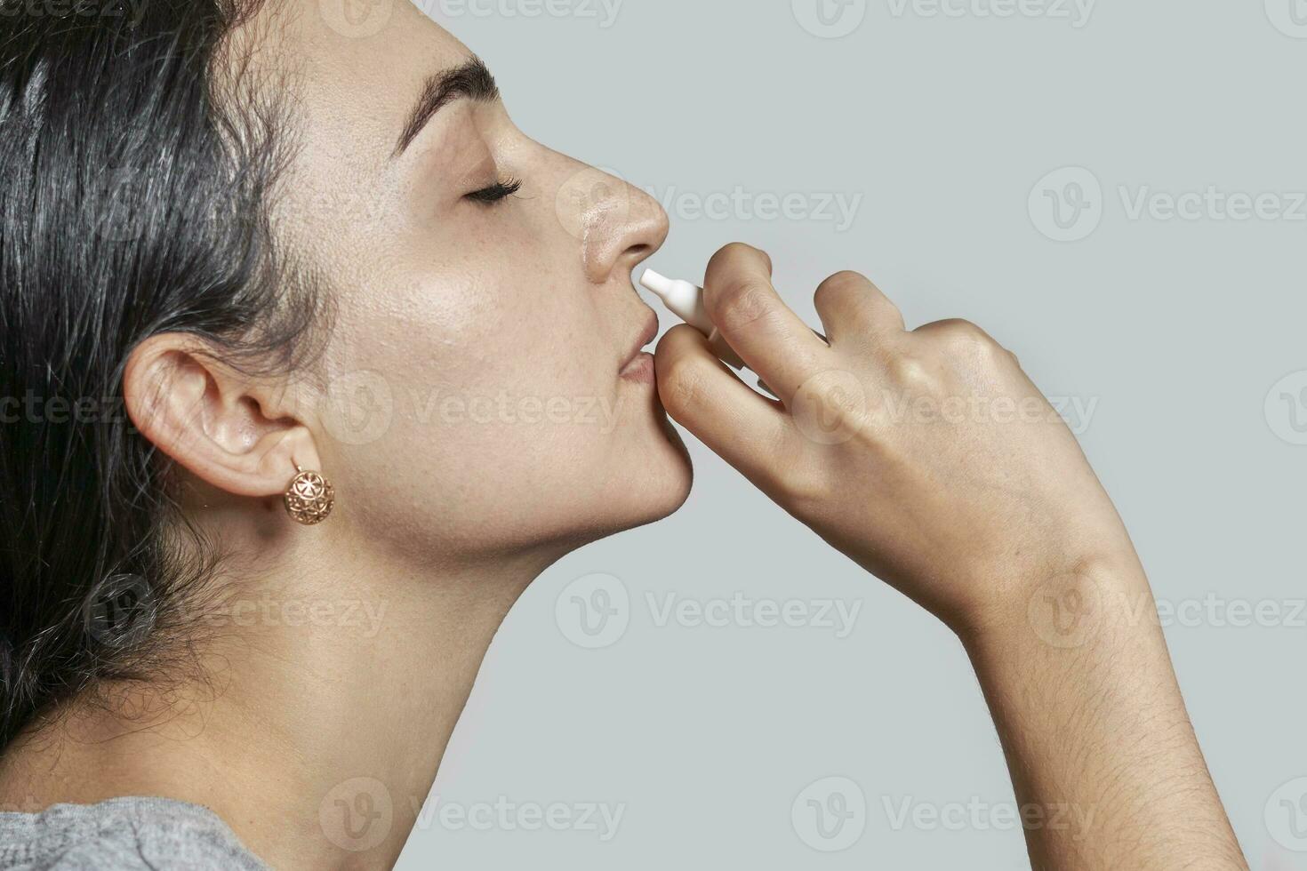 mujer utilizando nasal rociar foto