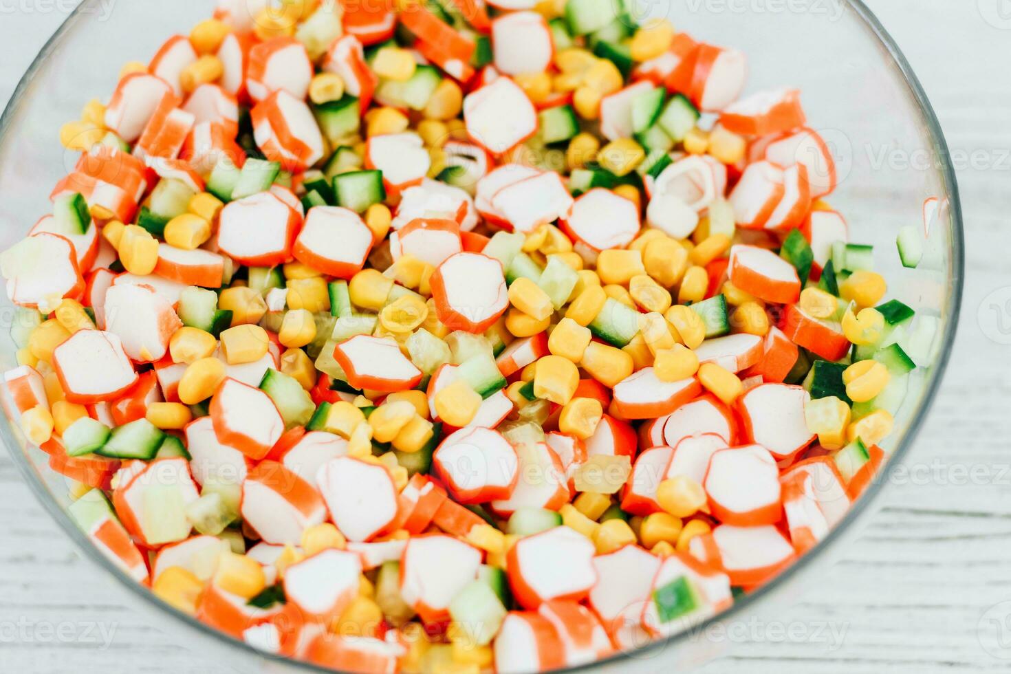 Salad from crab sticks, corn and fresh cucumber photo