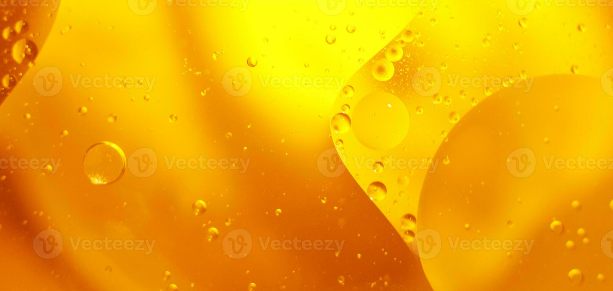 Gold Oil bubbles close up. circles of orange water macro. abstract shiny yellow background photo