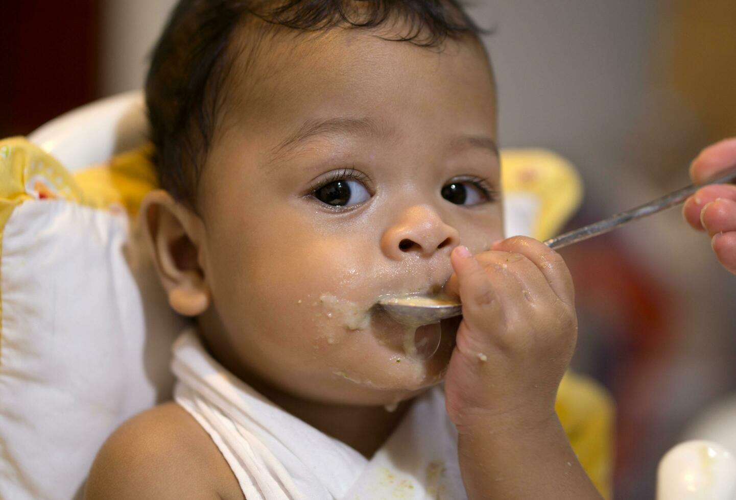 asiático bebé chico comer comida descuidado foto