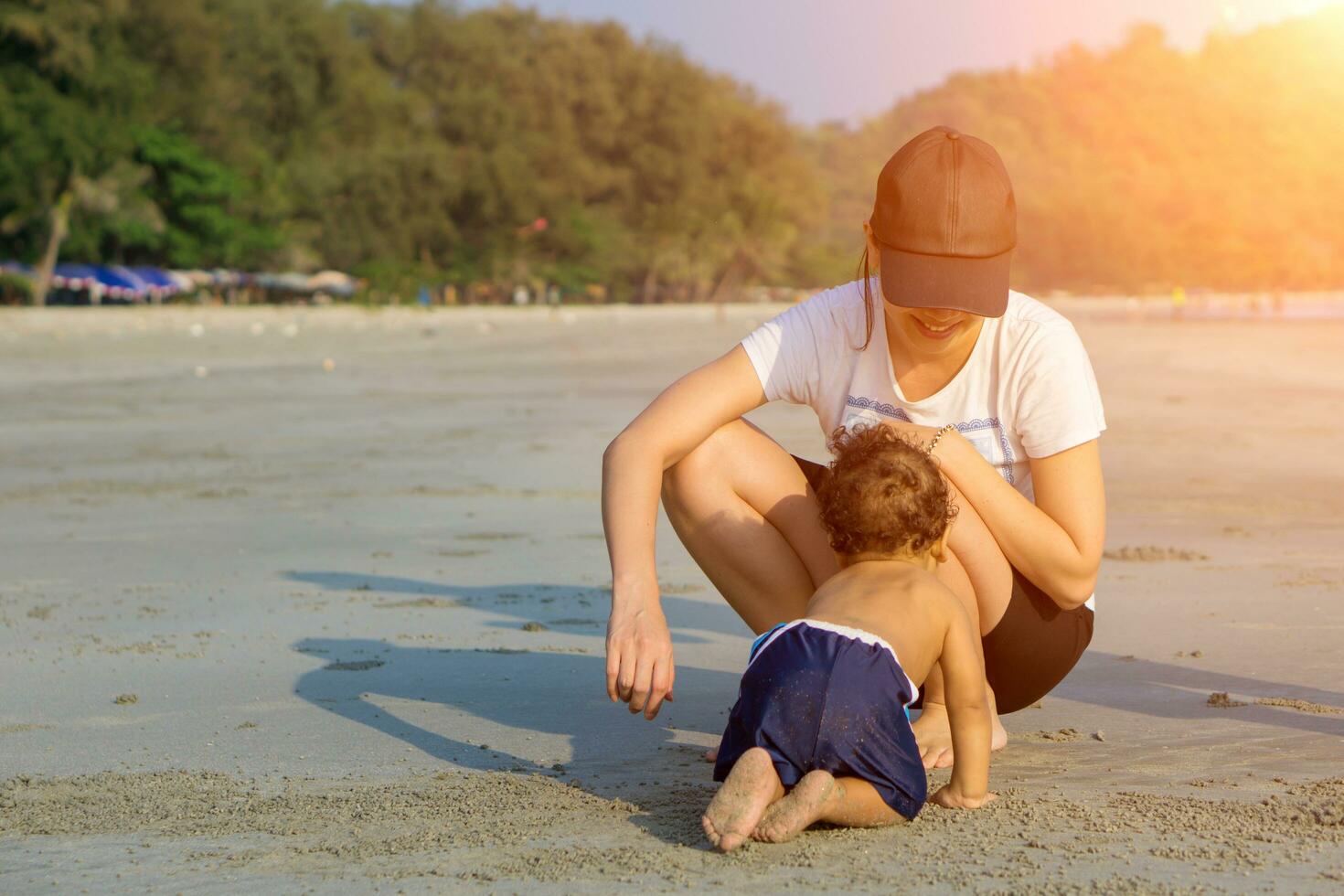 Mother and son playing on the beach photo