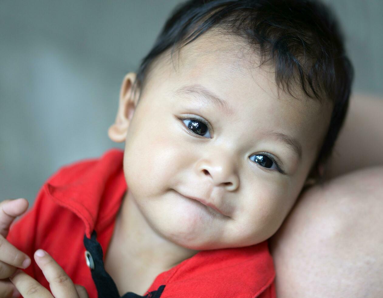 sonrisa asiático bebé en rojo camisa foto