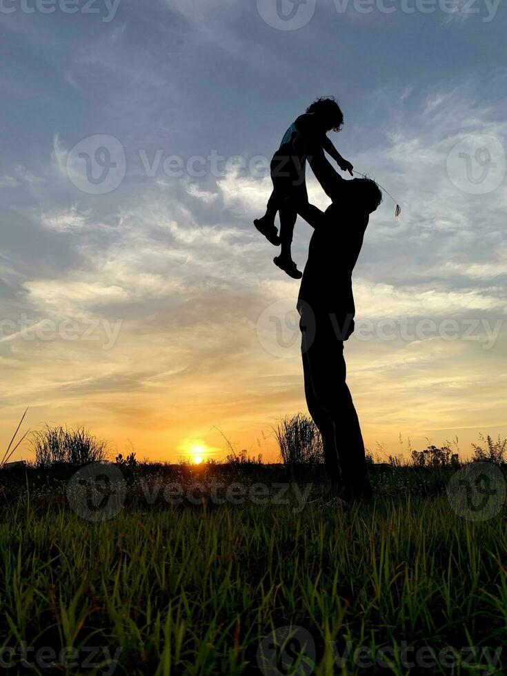 Silhouette Father Carrying Son Against Sky During Sunset photo