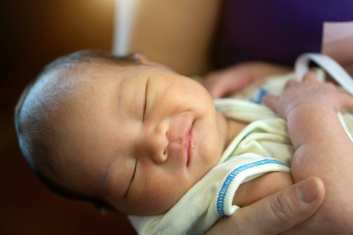 2-week-old Asian female baby being in her mother's arms photo