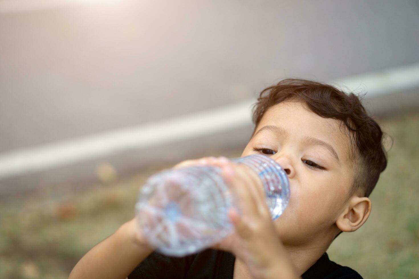 Asian thai kids drink water in park photo