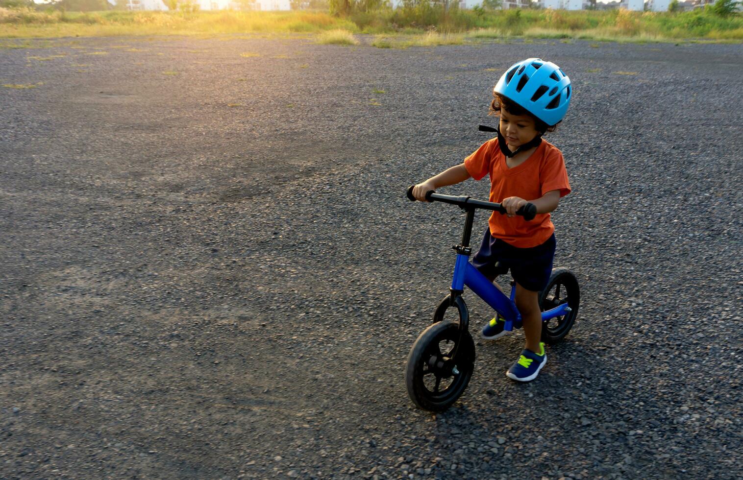 asiático niño primero día jugar equilibrar bicicleta. foto