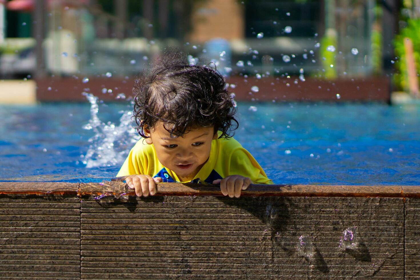 Asian child boy learn swimming in a swimming pool photo