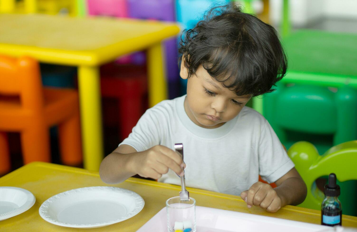 3 año antiguo niños en Asia son conductible científico experimentos foto