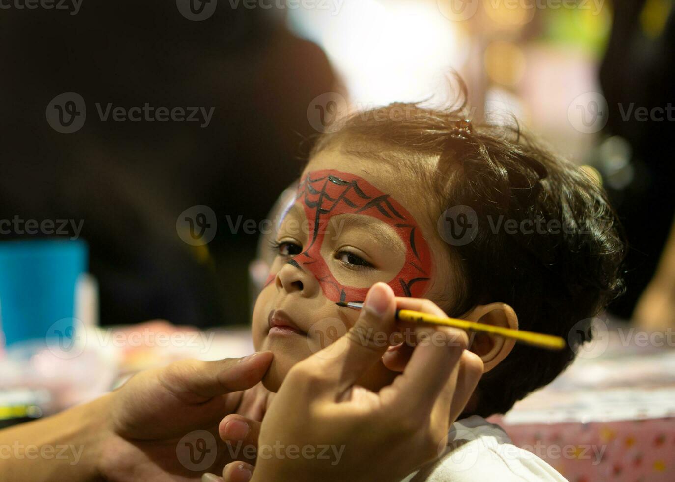 Asian kid boy with painted face as a spider photo