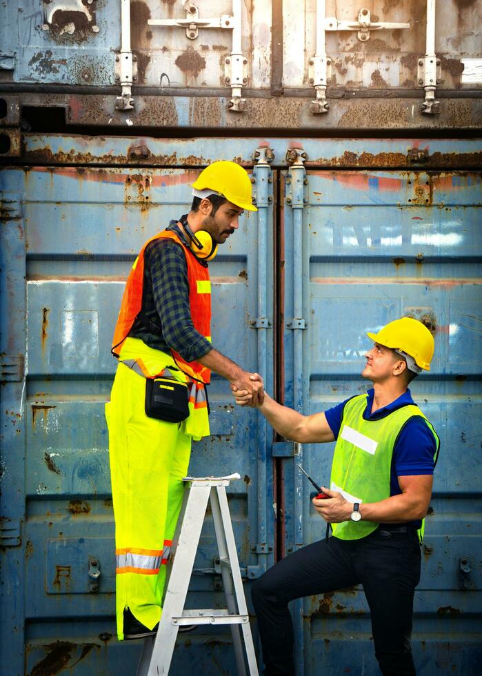 Two industrial workers join hands photo