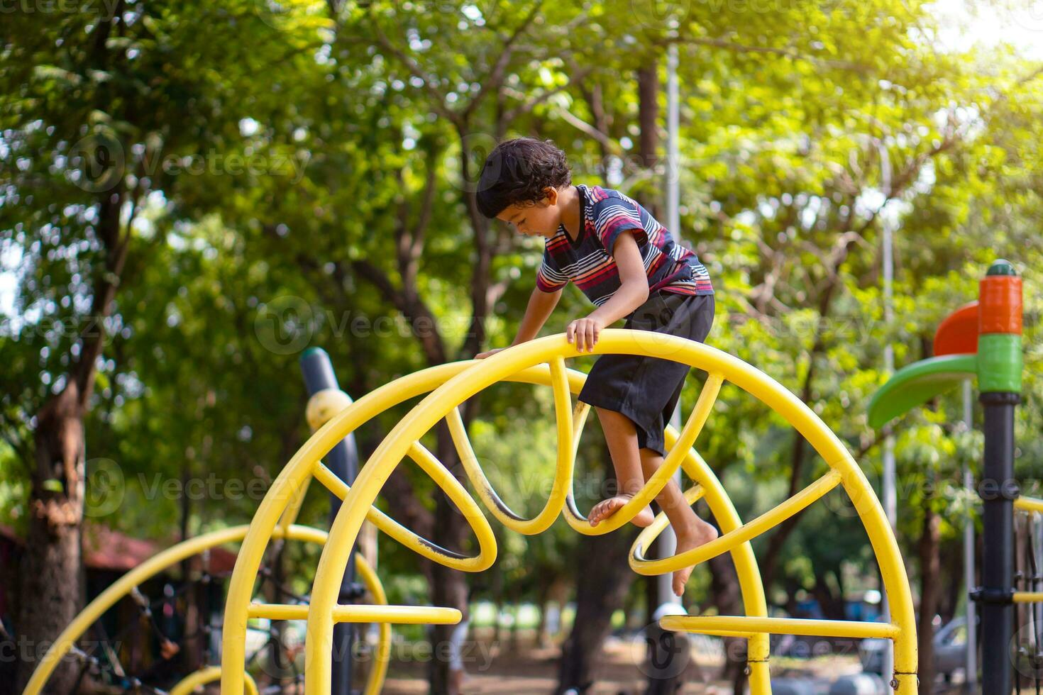 Asian boy is climbing on a playground equipment in a school. photo