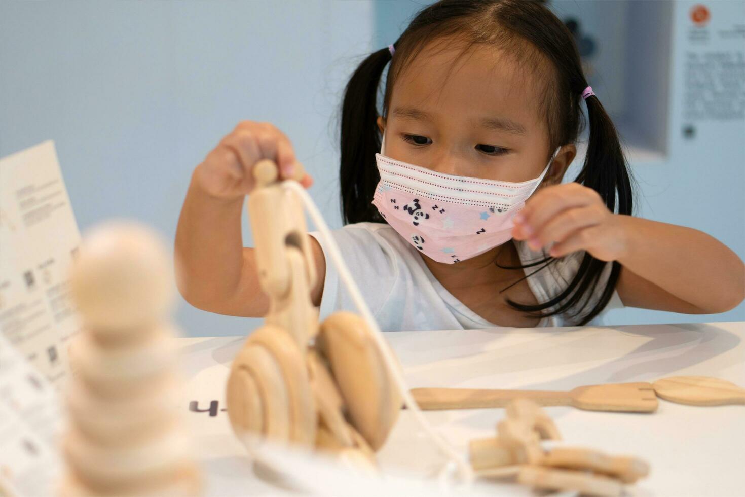 Asian girl wear face masks to prevent the Coronavirus 2019 and play toy in schools. photo